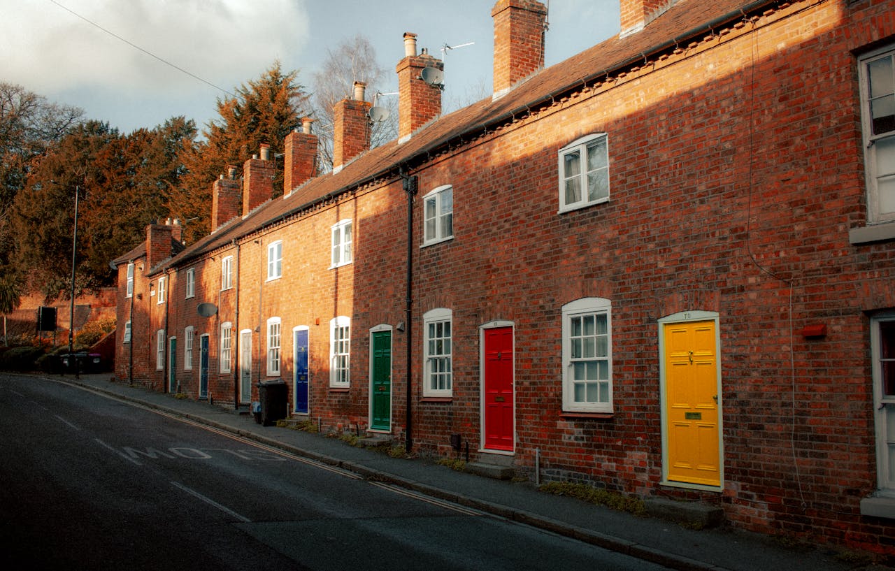 A picturesque street in Shrewsbury, England featuring a row of colorful brick houses and doors.